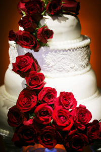 Four tiered, Round, White Wedding Cake With Red Cascading Roses
