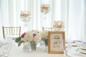 Wedding Reception Table Decor with Gold Framed Table Numbers, Candles, and Purple and White Floral Centerpieces