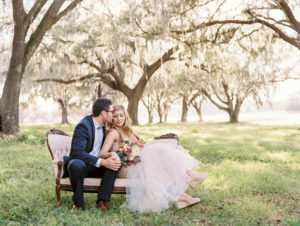 Bride and Groom Outdoor Tampa Wedding Portrait under Oak Trees on Vintage Seating | Tampa Bay Wedding Rentals Tufted Vintage Rentals
