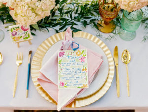 Wedding Reception Place Setting with Gold Charger and Gold Silverware with Watercolor Menu Card with PersonalIzed Cookie Favor with Name Card and Hydrangea Floral Decor | Tampa Wedding Rentals by Ever After Vintage Rentals