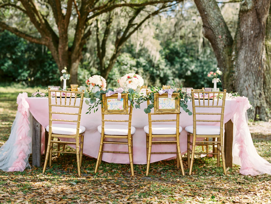 Outdoor Tampa Wedding Reception Seating with Watercolor Bride and Groom Chair Signs with Greenery with Gold Chiavari Chairs | Tampa Wedding Rental Chairs by Signature Event Rentals