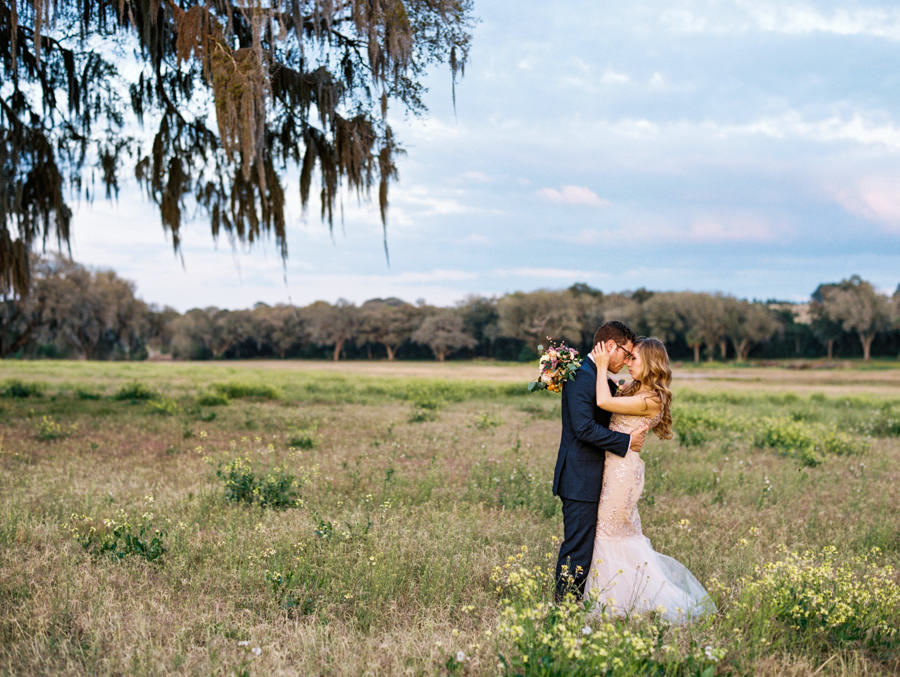 Bride and Groom Outdoor Tampa Wedding Portrait in Meadow of Greenery