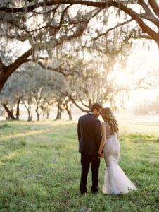 Bride and Groom Outdoor Tampa Wedding Portrait in Meadow of Greenery with Oak Trees