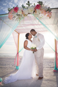 Pass-a-Grille, Waterfront Bride and Groom Beach Wedding Portrait Under Bamboo Wedding Altar with Pink and White Flowers | St. Pete Beach Wedding Planners Tide the Knot Beach Weddings