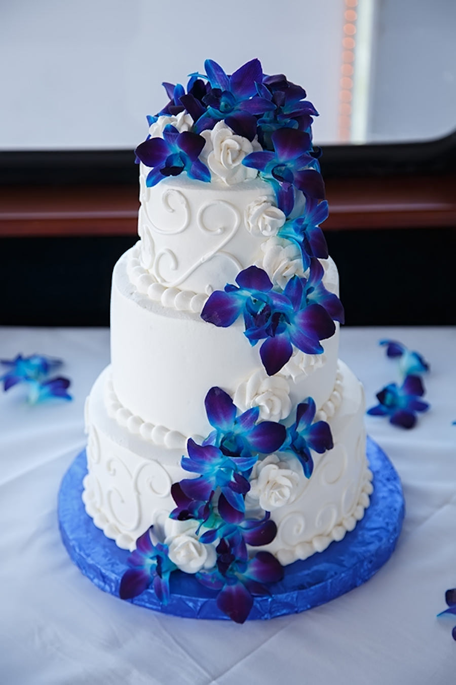 Round White Wedding Cake with Swirls and Blue Orchid Flowers