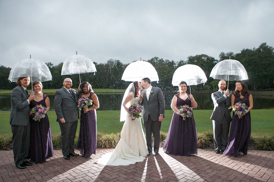 Outdoor, Bridal Party Portrait in the Rain with Clear Umbrellas and Purple Bridesmaids Dresses | Tampa Wedding Photographer Carrie Wildes Photography