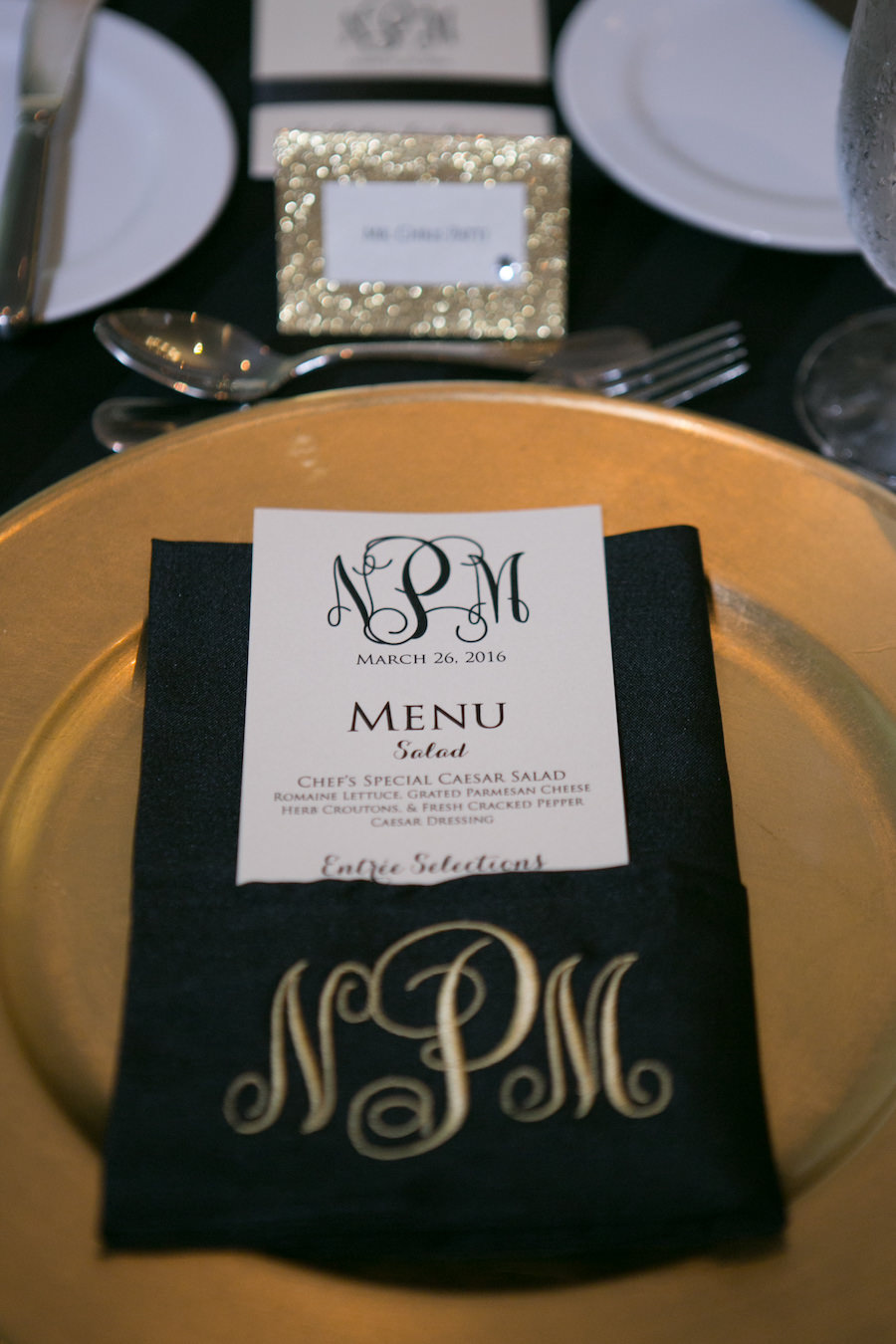 Black, Gold and Ivory Wedding Table Setting with Gold Chargers and Black Monogrammed Napkins