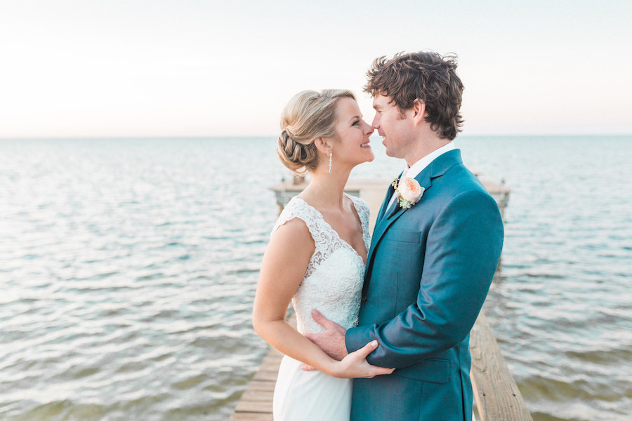 Outdoor, Tampa Bay Waterfront Bride and Groom Wedding Portrait on Boardwalk in Ivory, Lace, Allure Wedding Dress and Blue Groom's Suit