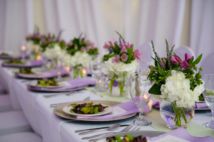 Garden Theme Wedding Reception Décor with Ivory, Purple and Green Wedding Centerpieces on White Linens with Silver Chargers | South Tampa Wedding Flowers by Apple Blossoms Floral Design | Tampa Wedding Photographer Kera Photography