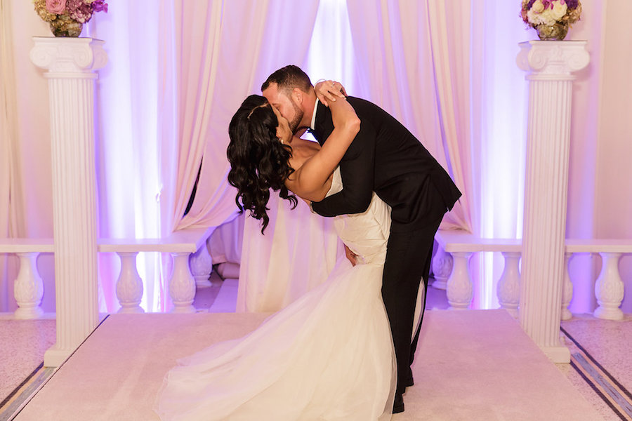 Wedding Portrait First Kiss with Purple Uplights with White Draping at Wedding Reception by Tampa Bay DJ Graingertainment