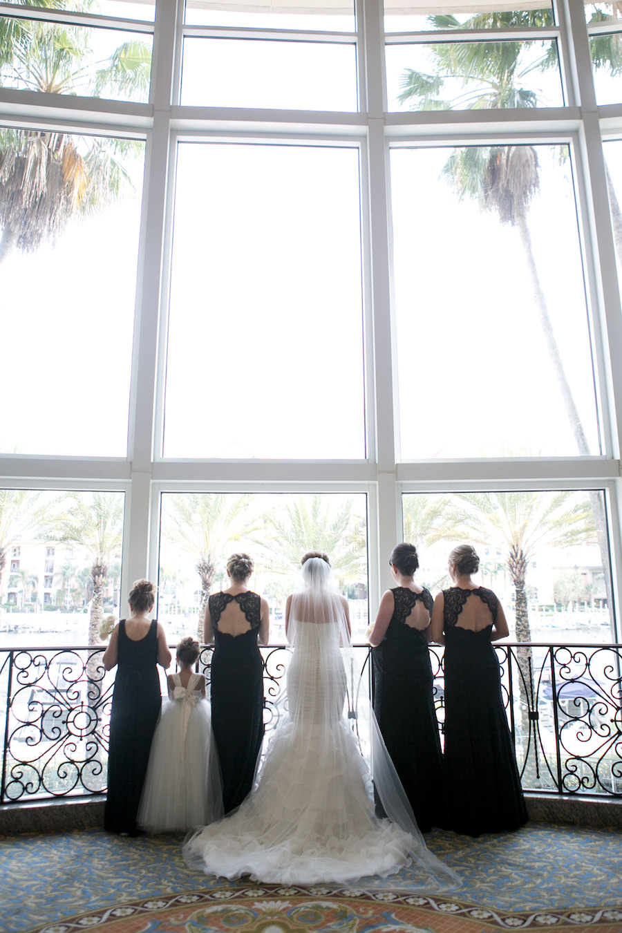 Bridal Party Wedding Portrait at Tampa Wedding Venue Marriott Waterside in Black Lace Bridesmaid Dresses from Bella Bridesmaid with Ivory Mermaid Style Wedding Gown | Wedding Photographer Carrie Wildes Photography
