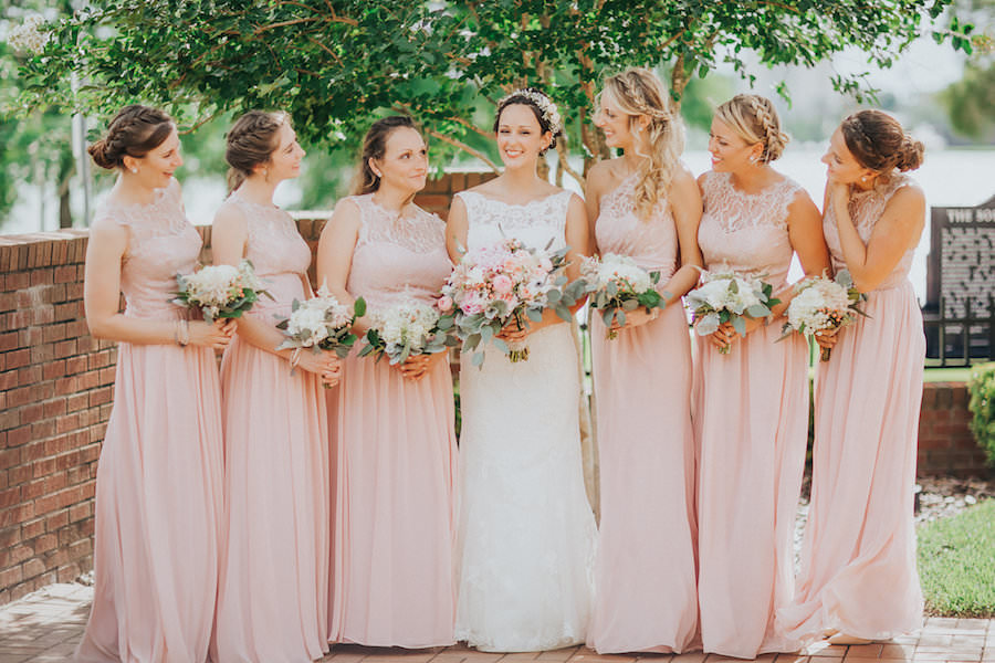 Outdoor, Bride and Bridesmaids Wedding Portrait in Pink Jim Hjelm Bridesmaids Dresses and Lacy, Ivory Wedding Dress | Tampa Bridesmaids Dress Shop Bella Bridesmaid