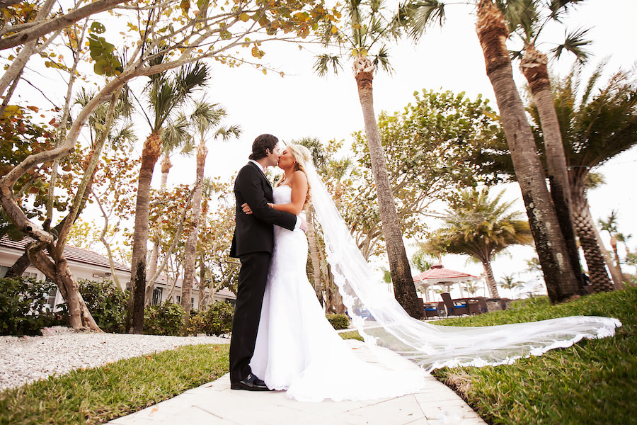 Bride and Groom Wedding Portrait in Black Tuxedo and White Lace Wedding Dress with Cathedral Veil | Clearwater Beach Florida Wedding Photographer Limelight Photography