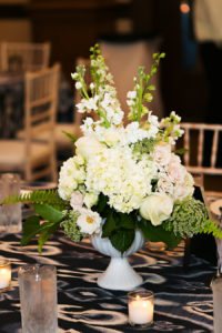 White Wedding Floral Centerpiece with Hydrangeas, Pink Roses and Greenery and Navy Blue Linens | Over the Top Linen Rentals