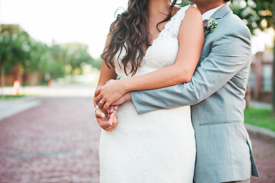 Outdoor, Bride and Groom Tampa Wedding Portrait in Lace, White Wedding Dress and Grey Groom's Suit in Ybor City