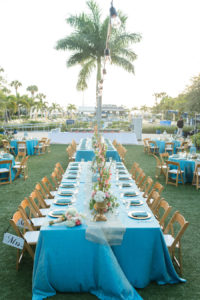 Outdoor, St. Petersburg Wedding Reception Table Decor with Wooden Chairs, Blue Table Linens, and Peach and Ivory Floral Wedding Centerpieces and Blue Lanterns | St. Petersburg Linens by Connie Duglin Linens | St. Petersburg Wedding Photographers Caroline and Evan Photography