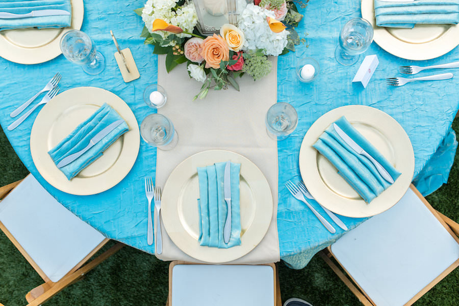 St. Petersburg Wedding Reception Table Decor with Gold Chargers, Ivory and Peach Floral Centerpieces and Blue Table Linens | St. Petersburg Rental Linens by Connie Duglin Linens