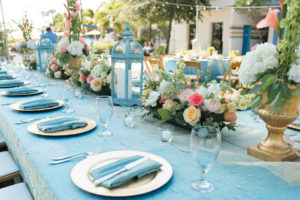 Outdoor, St. Petersburg Wedding Reception Table Decor with Wooden Chairs, Blue Table Linens, and Peach and Ivory Floral Wedding Centerpieces and Blue Lanterns | St. Petersburg Linens by Connie Duglin Linens
