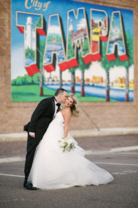 Downtown Tampa Mural Wedding Portrait | Bride and Groom Wedding Portrait in Black Tuxedo and White Strapless Sweetheart Hayley Paige Wedding Dress