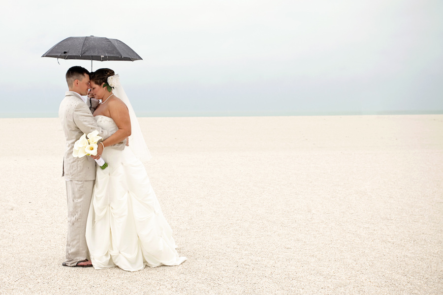 Outdoor Beach Wedding Portrait of Bride and Groom in the Rain with Umbrella | Andi Diamond Photography