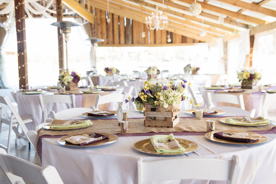 Plant City Barn Wedding Reception Table Decor with Gold Chargers, Burlap Table Runners, and Purple and Yellow Floral Centerpieces