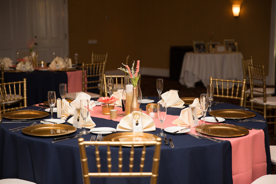 Tampa Wedding Reception Table Decor with Gold Chiavari Chairs, Gold Chargers. Pink Table Runner, and Coral Flower Centerpieces