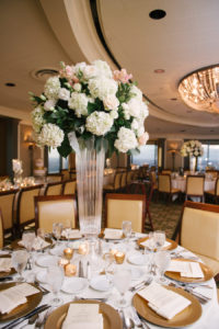Elegant Indoor Tampa Wedding Venue with Tall Centerpieces with Hydrangeas and Roses and Chandeliers with Gold Charger Plates | The Tampa Club