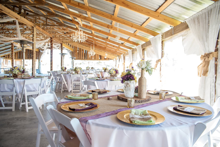 Plant City Barn Wedding Reception Table Decor with Gold Chargers, Burlap Table Runners, and Purple and Yellow Floral Centerpieces, and Wooden Slabs