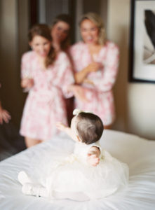 Bridesmaids Laughing with Flower Girl on Wedding Day