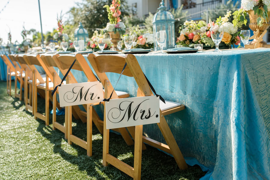 Outdoor, St. Petersburg Wedding Reception Table Decor with Wooden Chairs, Blue Table Linens, and Peach and Ivory Floral Wedding Centerpieces | St. Petersburg Linens by Connie Duglin Linens