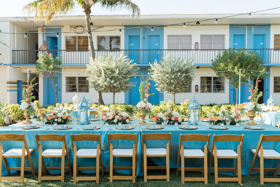 Outdoor, St. Petersburg Wedding Reception Table Decor with Wooden Chairs, Blue Table Linens, and Peach and Ivory Floral Wedding Centerpieces and Blue Lanterns | St. Petersburg Linens by Connie Duglin Linens | St. Petersburg Wedding Photographers Caroline and Evan Photography