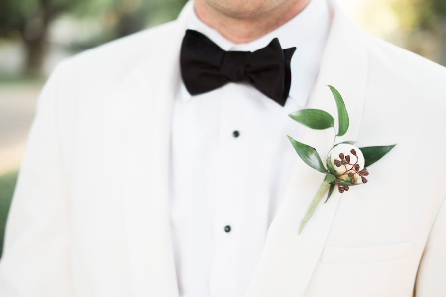 Groom Wedding Portrait in White Tuxedo with Black Tie and White Boutonniere