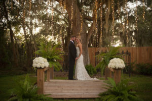 Outdoor, Bride and Groom Wedding Portrait Under Mossy Oak Tree with Twinkle Lights on Love Lock Bridge at Sarasota Wedding Venue Bakers Ranch