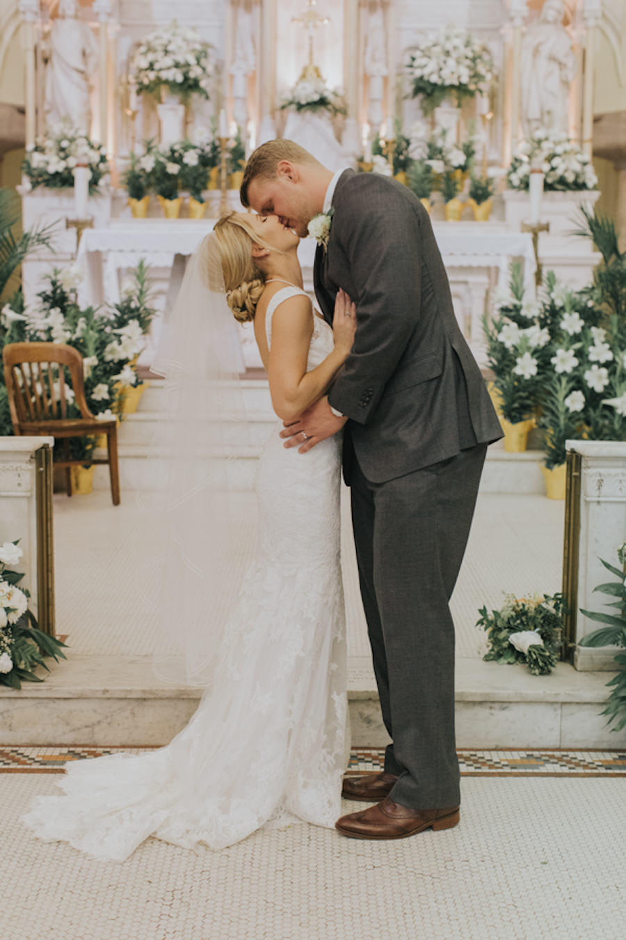Bride and Groom Kissing at Altar at Wedding Ceremony | Historic Downtown Tampa Wedding Venue Sacred Heart Catholic Church | Cleveland Browns Football Player Charley Hughlett Wedding