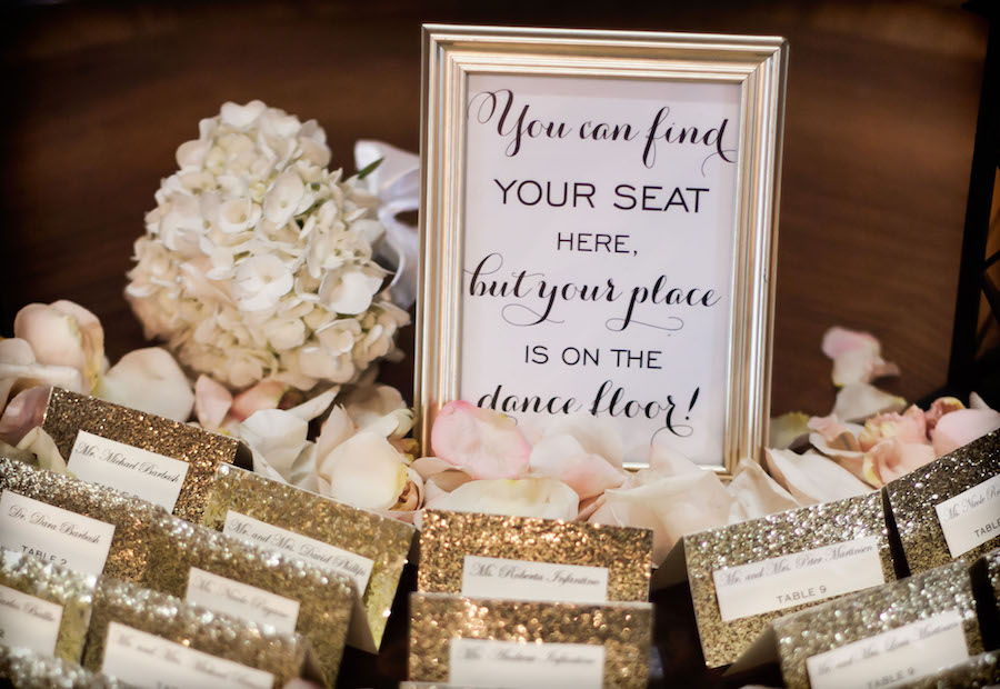 Wedding Reception Guest Seating Table with Gold Glitter Place Cards and Seating Chart Signage