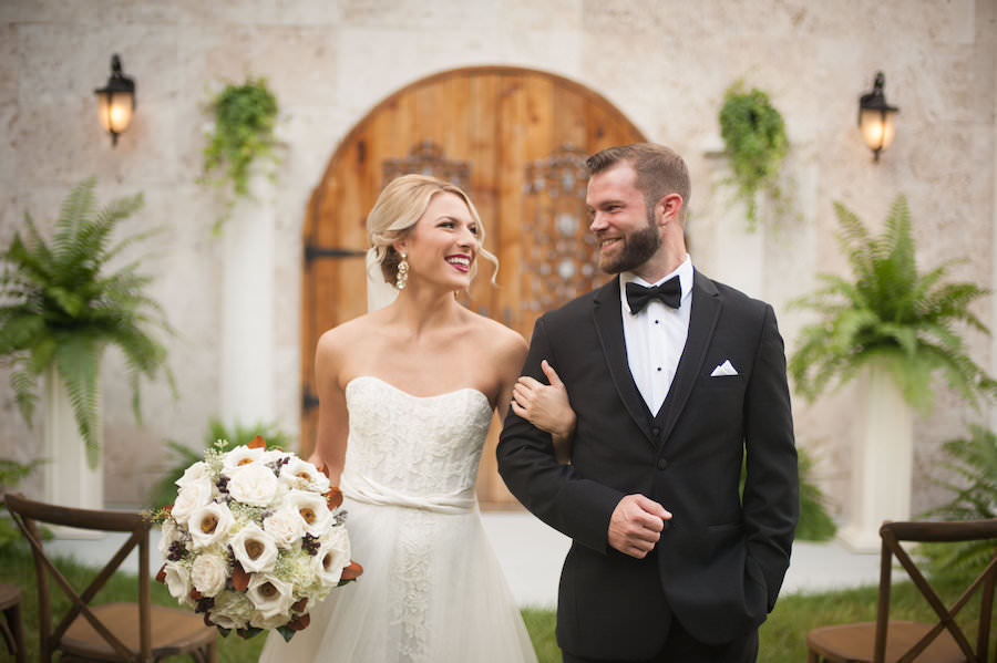 Outdoor, Bride and Groom Wedding Ceremony Portrait in Black Tuxedo and Ivory Strapless Wedding Dress with Detachable Chiffon Skirt and Large Ivory and Brown Floral Wedding Bouquet | | Sarasota Wedding Venue Bakers Ranch | Southern Wedding Inspiration