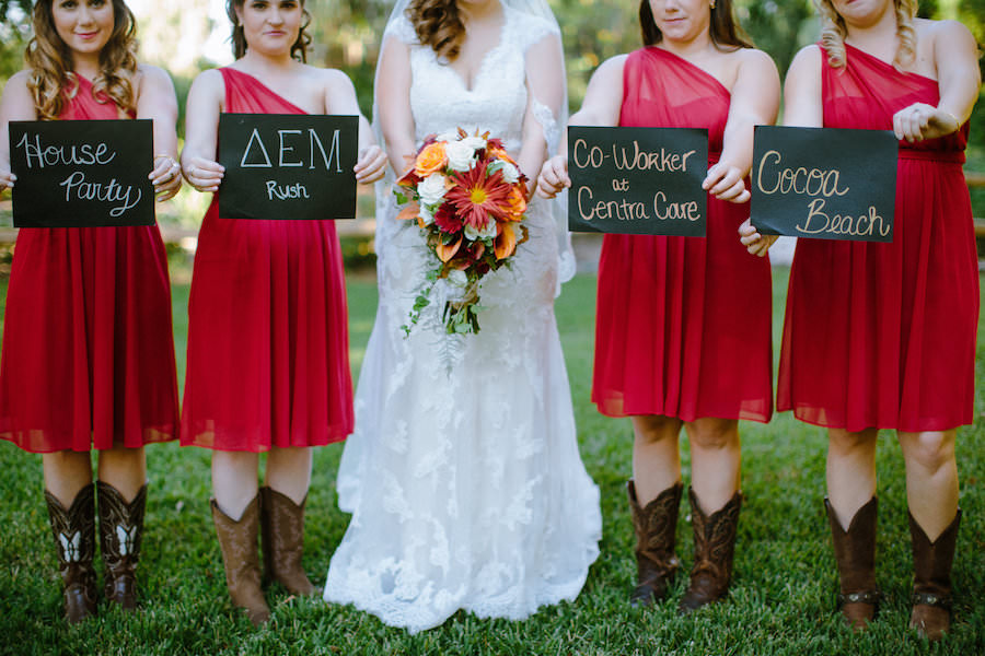 Bride and Bridesmaids Dover Wedding Portrait with Signs of How They Met in Red Bridesmaids Dresses and Cowgirl Boots