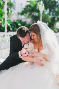 Bride and Groom Wedding Portrait with Pet Dog at Tampa Bay Pet Friendly Wedding Venue Loews Don CeSar Hotel | Tampa Wedding Day Pet Care by FairyTail Pet Care | Photography by Roohi Photography