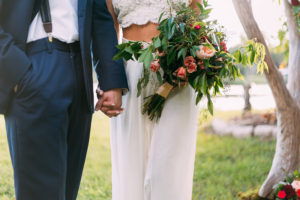 Bride and Groom Wedding Portrait in Two Piece Wedding Dress with Bouquet with Greenery Accents