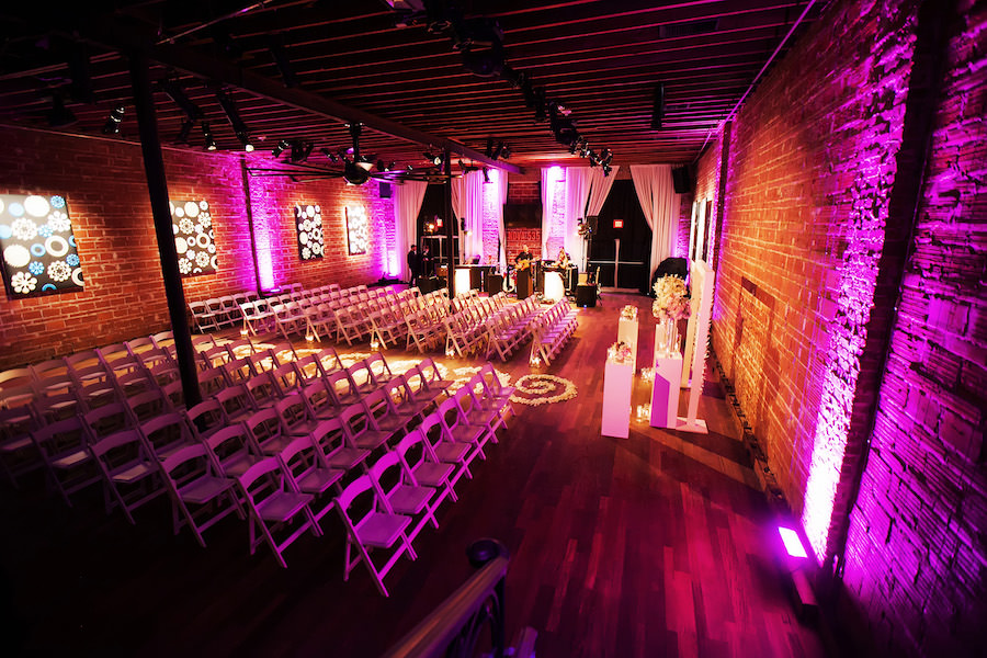 Indoor, St Petersburg Wedding Ceremony with Exposed Brick Walls and Purple Uplighting | St. Petersburg Wedding Venue NOVA 535