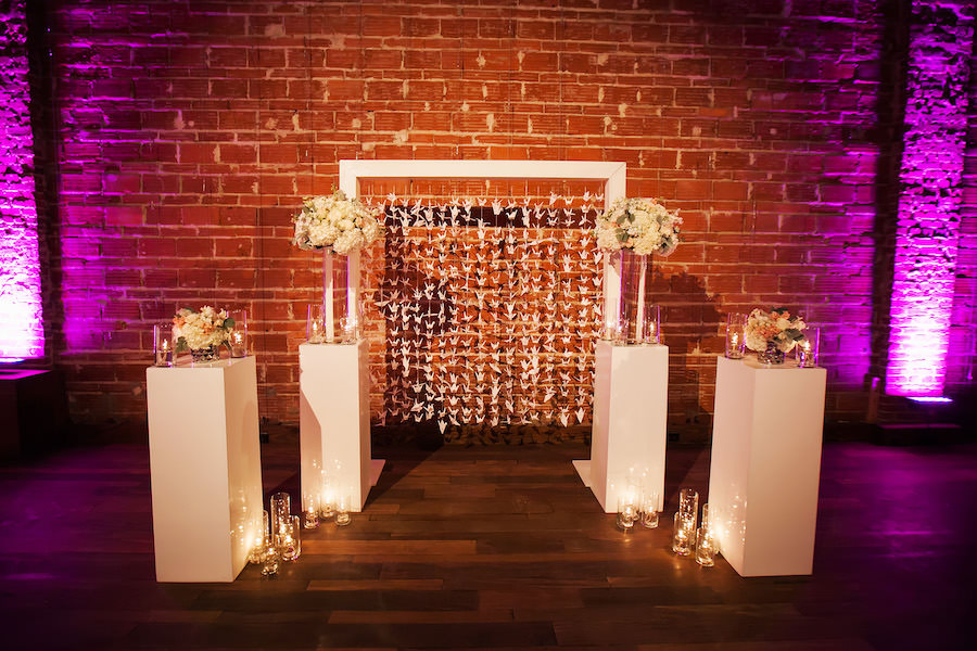 Paper Crane Backdrop and Ivory Floral Wedding Ceremony Altar Arrangements with Exposed Brick Wall | St. Petersburg Wedding Venue NOVA 535