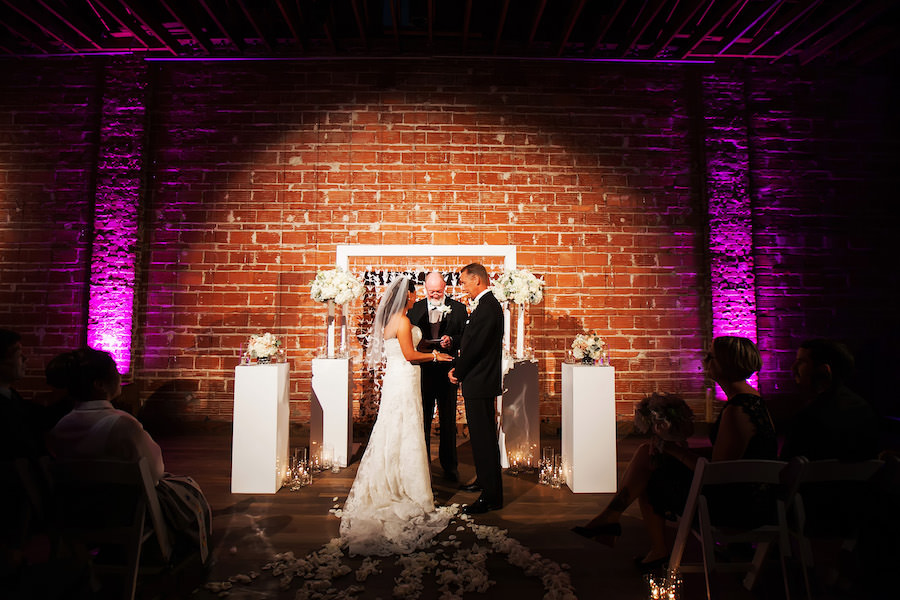 Bride and Groom Exchanging Vows at Indoor, Wedding Ceremony with Exposed Brick Walls and Purple Uplighting | Modern Wedding Ceremony Ideas | St. Petersburg Wedding Venue NOVA 535 | Wedding Photographer Limelight Photography