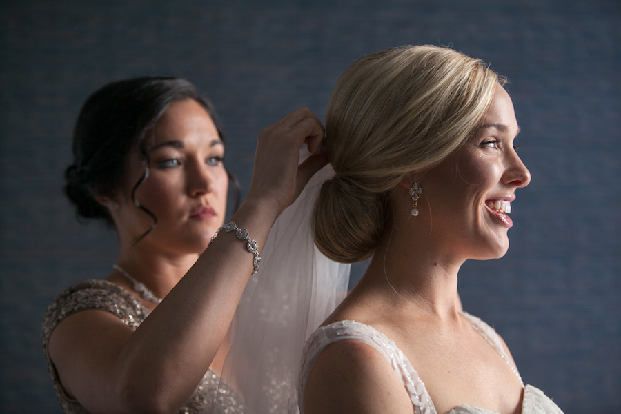 Bridal Getting Ready Portrait | Bridesmaid Helping Bride Pin Veil To Hair | Downtown Tampa Wedding Photographer Carrie Wildes Photography