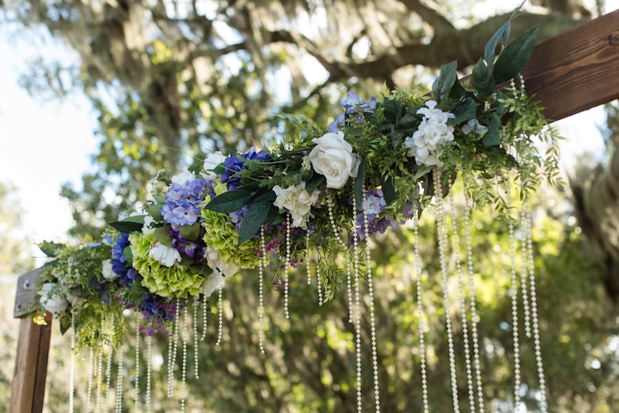 Rustic Glam Wedding Ceremony Wooden Arch with Ivory Roses, Green and Purple Hydrangeas and Cascading Pearls | Tampa Bay Wedding Venue Cross Creek Ranch