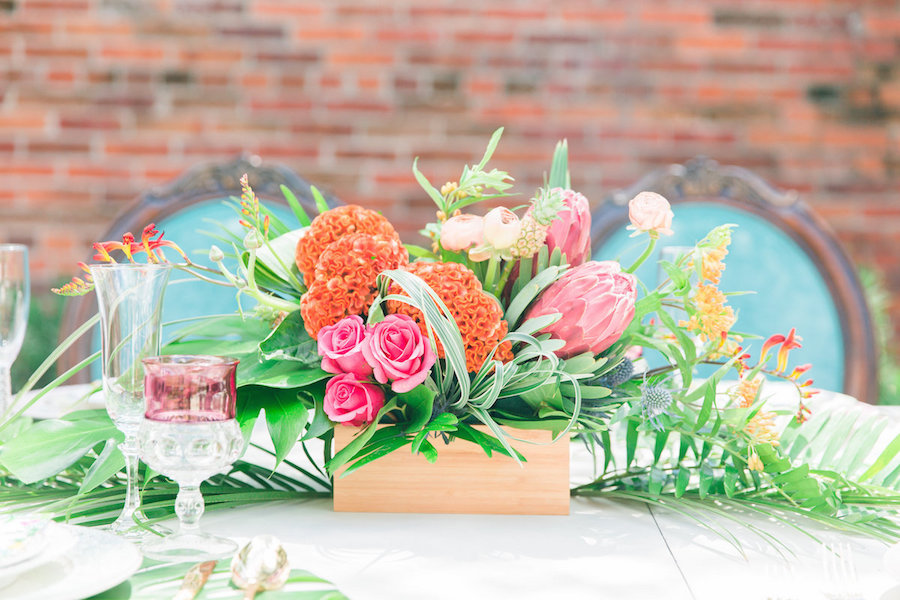 Tropical, Lilly Pulitzer Inspired Wedding Table Runner and Centerpieces with Pink Roses and Proteas with Tropical Leaves and Vibrant Florals with Teal Vintage Chairs | The Reserve Vintage Rentals