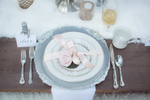 Outdoor Winter Inspired Wedding Reception with Faux Fur and Wooden Farm Tables with Silver Charger Plates with Vintage China Dishes | Ever After Vintage Weddings Tampa Bay Wedding Rental Company and Event Stylist