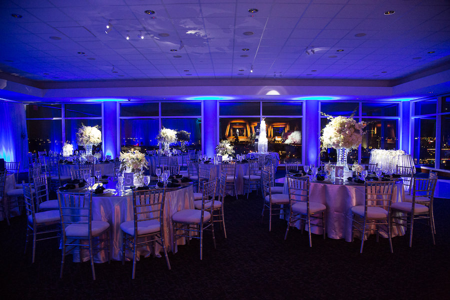 Indoor, Winter Wonderland Wedding Reception Decor with Blue Uplighting and Tall Ivory Table Centerpieces with Pinspotting | Tampa Wedding Planner UNIQUE Weddings and Events