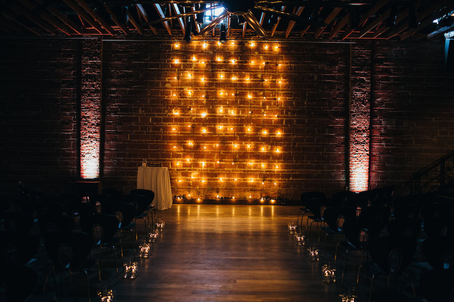 Modern, Industrial Wedding Ceremony with Lighted Backdrop Decor Against Brick Wall | Downtown St. Pete Wedding Venue NOVA 535