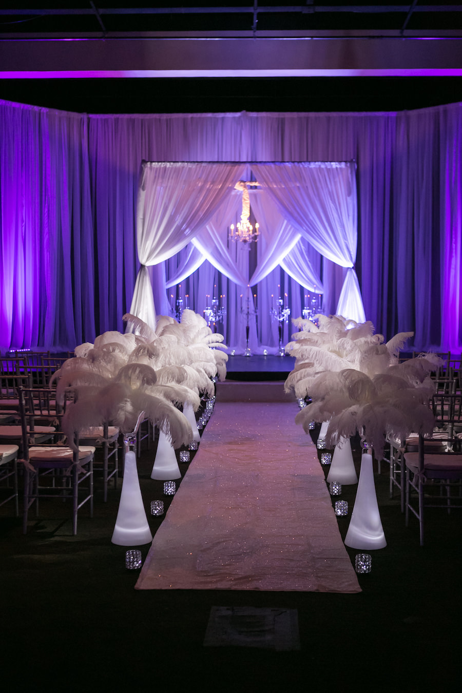 Purple Uplighting and Pin-spotting Lighting Effects for Florida Modern Wedding Ceremony with Drapery and Chiavari Chairs with Feather Aisle Decor by Tampa Event Rental Company Gabro Event Services
