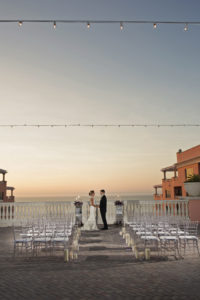 Sunset Candlelit Ceremony Aisle with Purple Rose Petals and Clear Chiavari Chairs | Clearwater Beach Wedding Venue Hyatt Regency | Wedding Planner Special Moments Event Planning | Chair Rentals Gabro Event Services | Djamel Photography